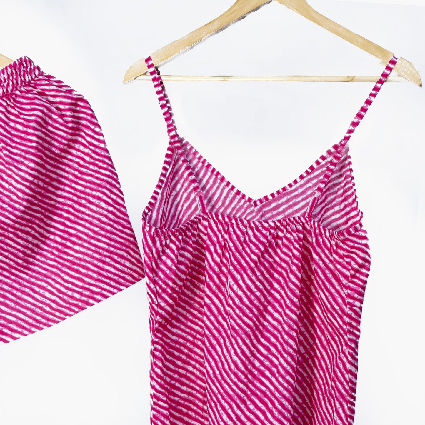 Pink striped cami set and shorts against a white background on a wooden hanger.