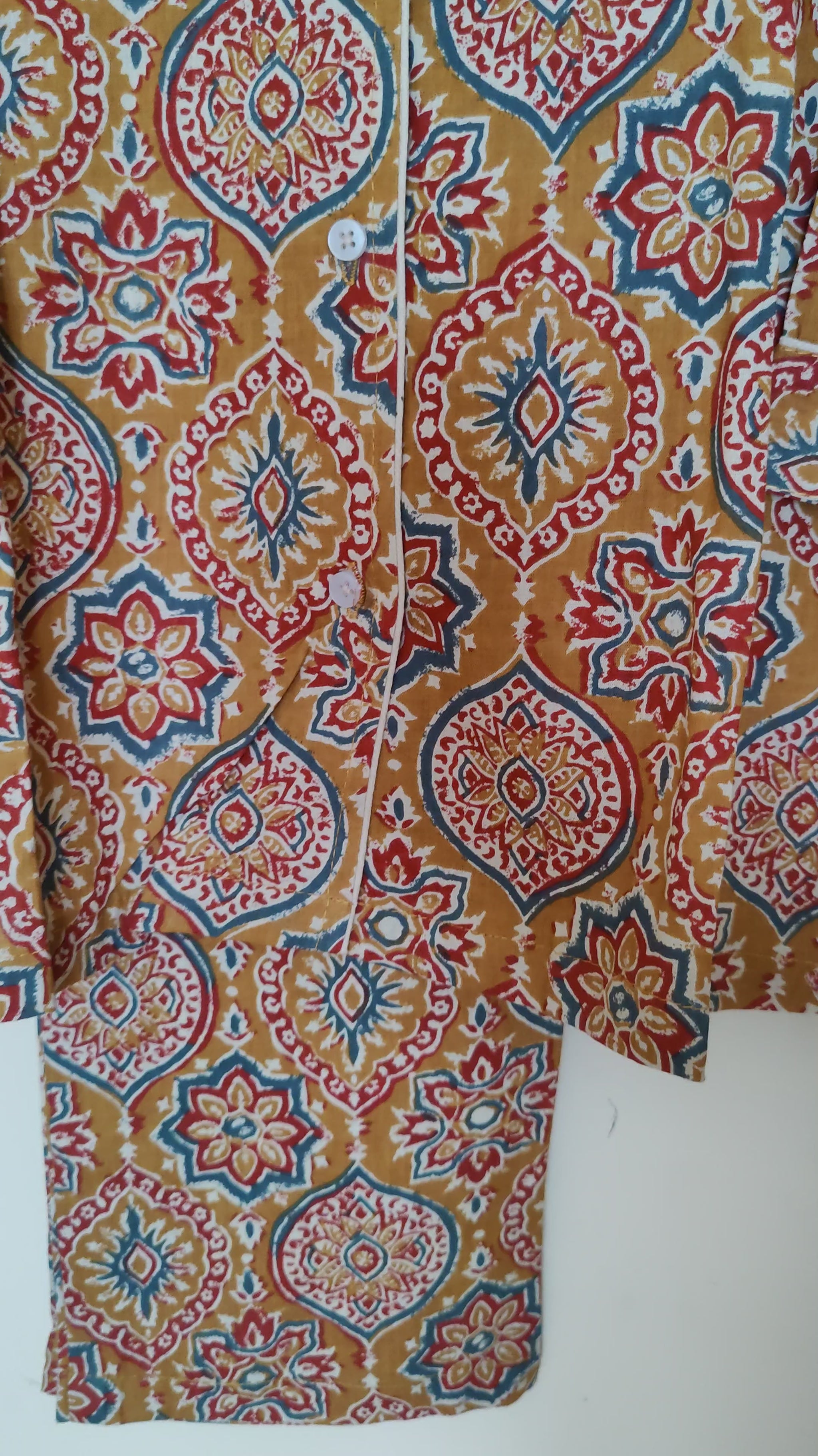 close up video of mustard ajrakh print Dharti pjs hanging on a wall.
